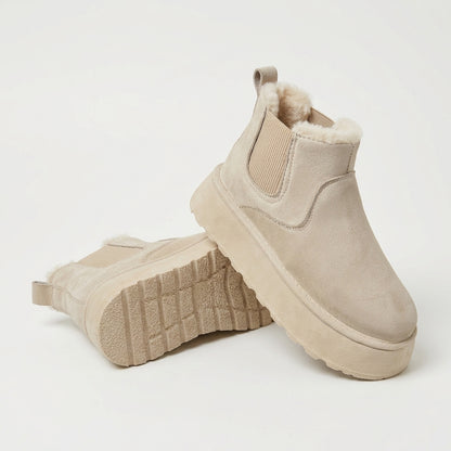Botas de invierno premium de ante beige con plataforma, vista del par y la suela sobre fondo claro