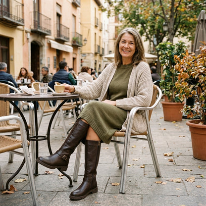 Mujer sentada en una terraza con vestido de punto y botas Sara marrón oscuro