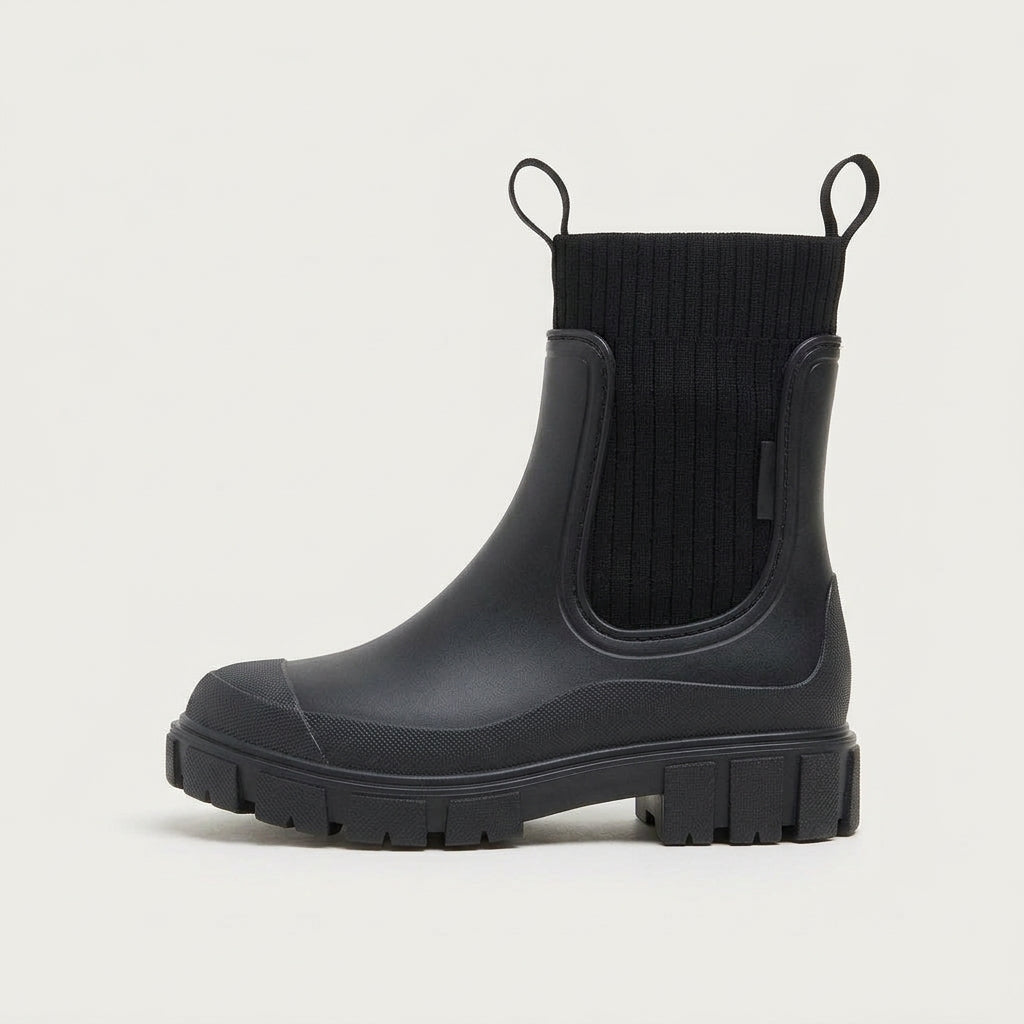 Bota impermeable Irene negra de perfil con caña de punto y suela dentada