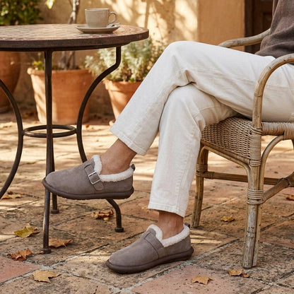 Mujer sentada en una terraza con pantalón blanco y zapatillas Lucía caqui